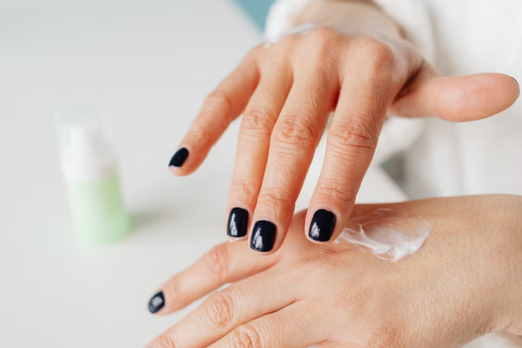 Woman applying skincare cream, representing biomimetic peptide activity in skin signaling and renewal.